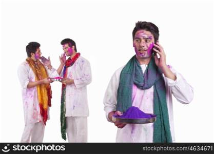 Young man with holi colour talking on a mobile phone