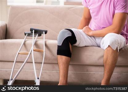 Young man with injured knee recovering at home