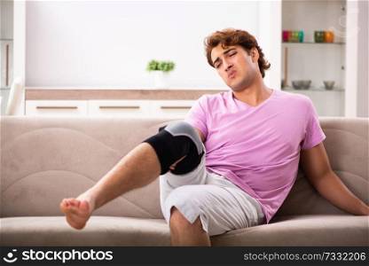 Young man with injured knee recovering at home