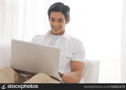Young man with laptop smiling