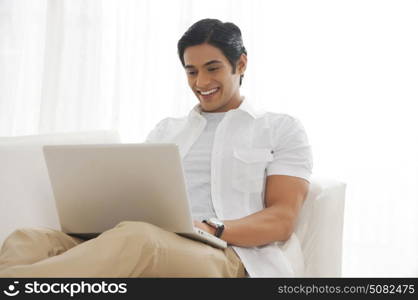 Young man with laptop smiling