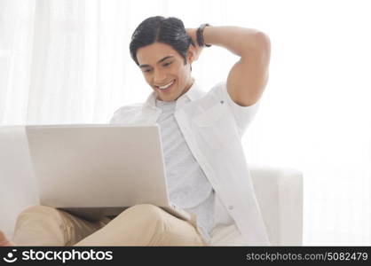 Young man with laptop smiling