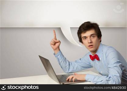 Young man with laptop. Young man in casual chatting using laptop