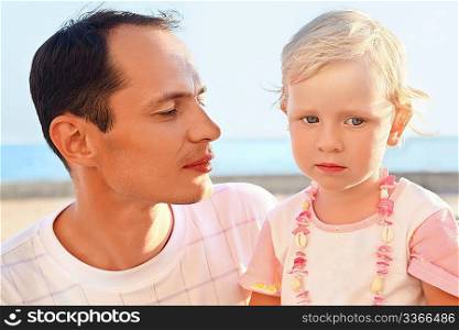 young man with little girl on beach
