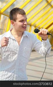 young man with microphone on footbridge
