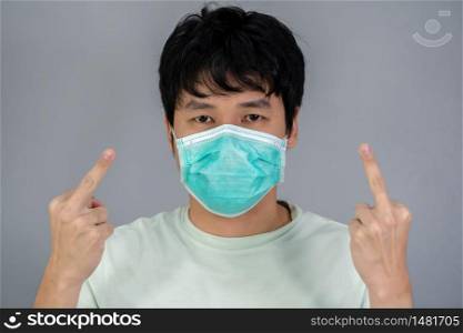 young man with middle finger fuck sign hand gesture, coronavirus protection