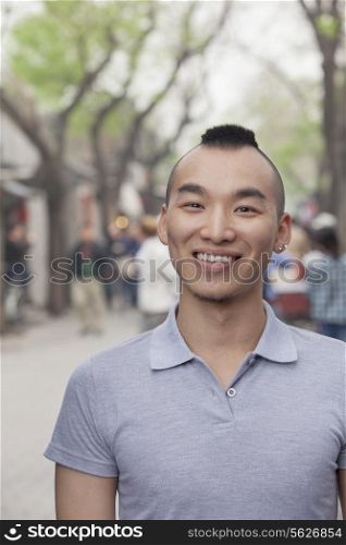 Young Man with Mohawk haircut smiling looking at camera