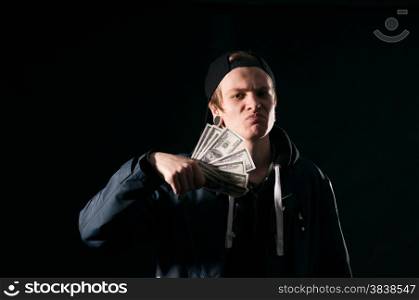young man with money in his hands on dark background