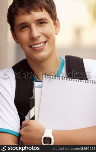 young man with notebooks, selective focus on eye, natural light