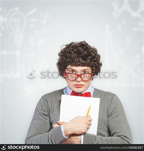 Young man with papers. Young man in glasses standing and holding papers