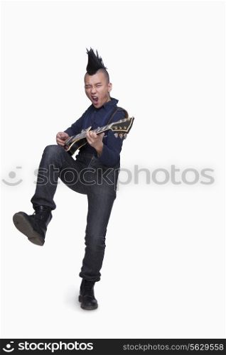 Young man with punk Mohawk playing guitar