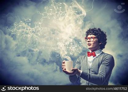 Young man with smoke coming out of cup. Young man with smoke coming out of a cup experimenting