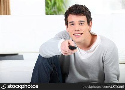 Young man with TV remote