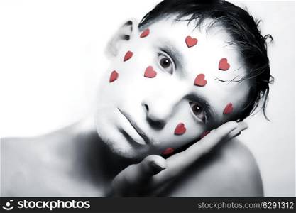young man with white makeup and red hearts on face