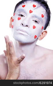 young man with white makeup and red hearts on face