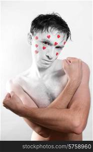 young man with white makeup and red hearts on the face