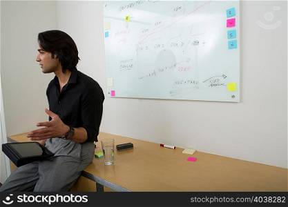 Young man with whiteboard in background
