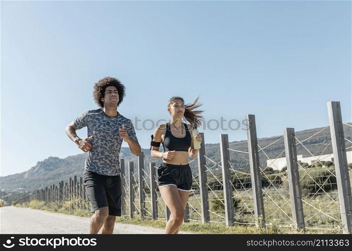 young man woman running road
