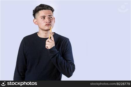 young man wondering with his hand on his chin on an isolated background, a guy thinking with his hand on his chin.