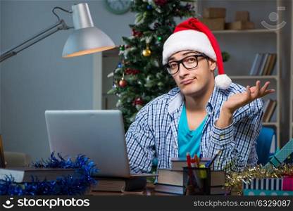 Young man working at home on christmas day. The young man working at home on christmas day