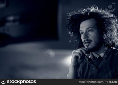 Young man working on computer at night in dark office. The designer works in the later time.