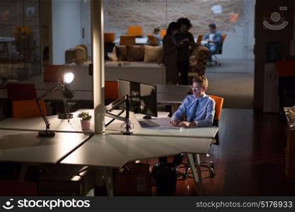 Young man working on computer late at night in the office