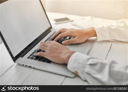 Young man working on his laptop with blank copy space screen for your advertising text message in office, sitting at the wooden desk  