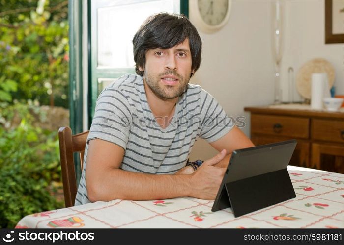 young man working with a tablet pc on a table at home