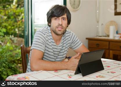 young man working with a tablet pc on a table at home