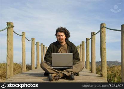 young man working with computer at the beach