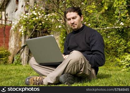 young man working with laptop at the garden