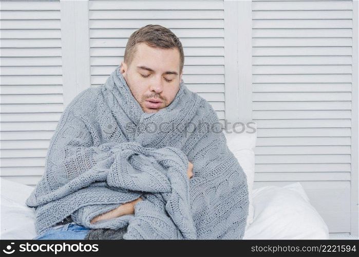 young man wrapped warm scarf shivering from cold