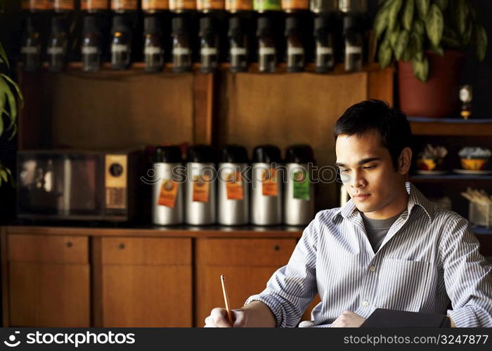 Young man writing with a pencil