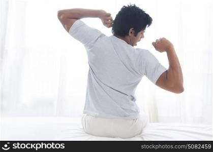 Young man yawning and stretching
