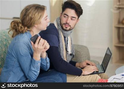 young married couple using laptop