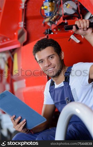 young mechanic looking at camera