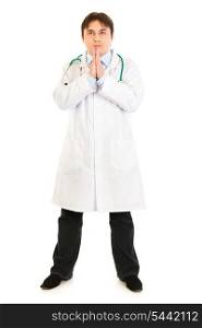 Young medical doctor praying for success isolated on white&#xA;
