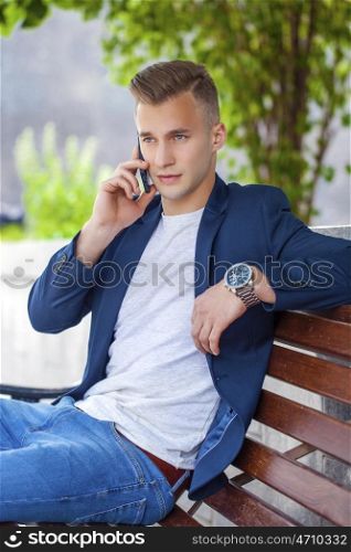 Young men calling by phone in summer street