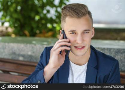 Young men calling by phone in summer street