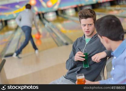 Young men chatting at the bowling alley
