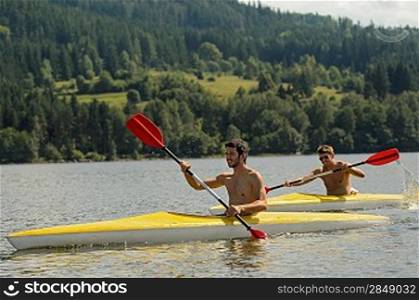 Young men kayaking summertime vacation on river paddling