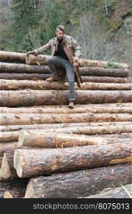 Young men on logs in the forest. Leather and jeans. Outdoor fashion