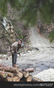 Young men on logs in the forest. Leather and jeans. Outdoor fashion