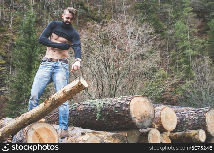 Young men on logs in the forest. Men dress.