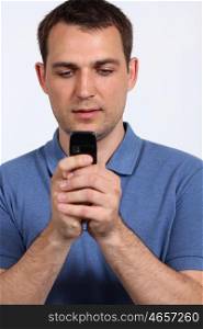 Young men sending a sms with his mobile phone