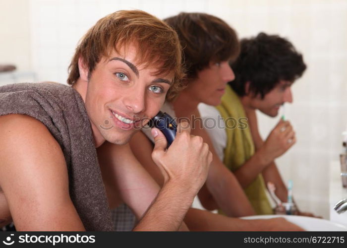 young men shaving and brushing teeth