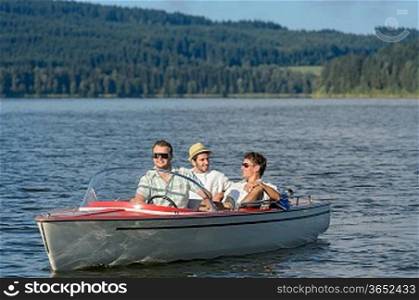 Young men sitting in motorboat in scenic landscape