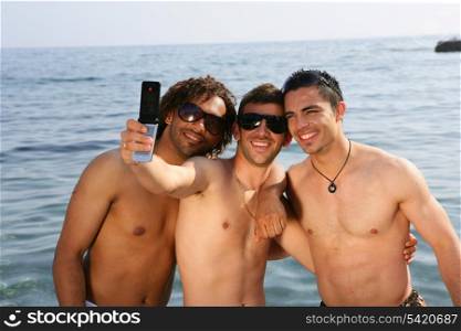 Young men taking pictures at the beach