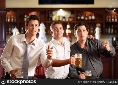 Young men with a beer watching the match in the bar