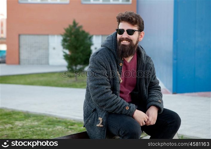 Young men with hipster look sitting on a bench in street